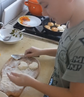 Дитина готує вареники